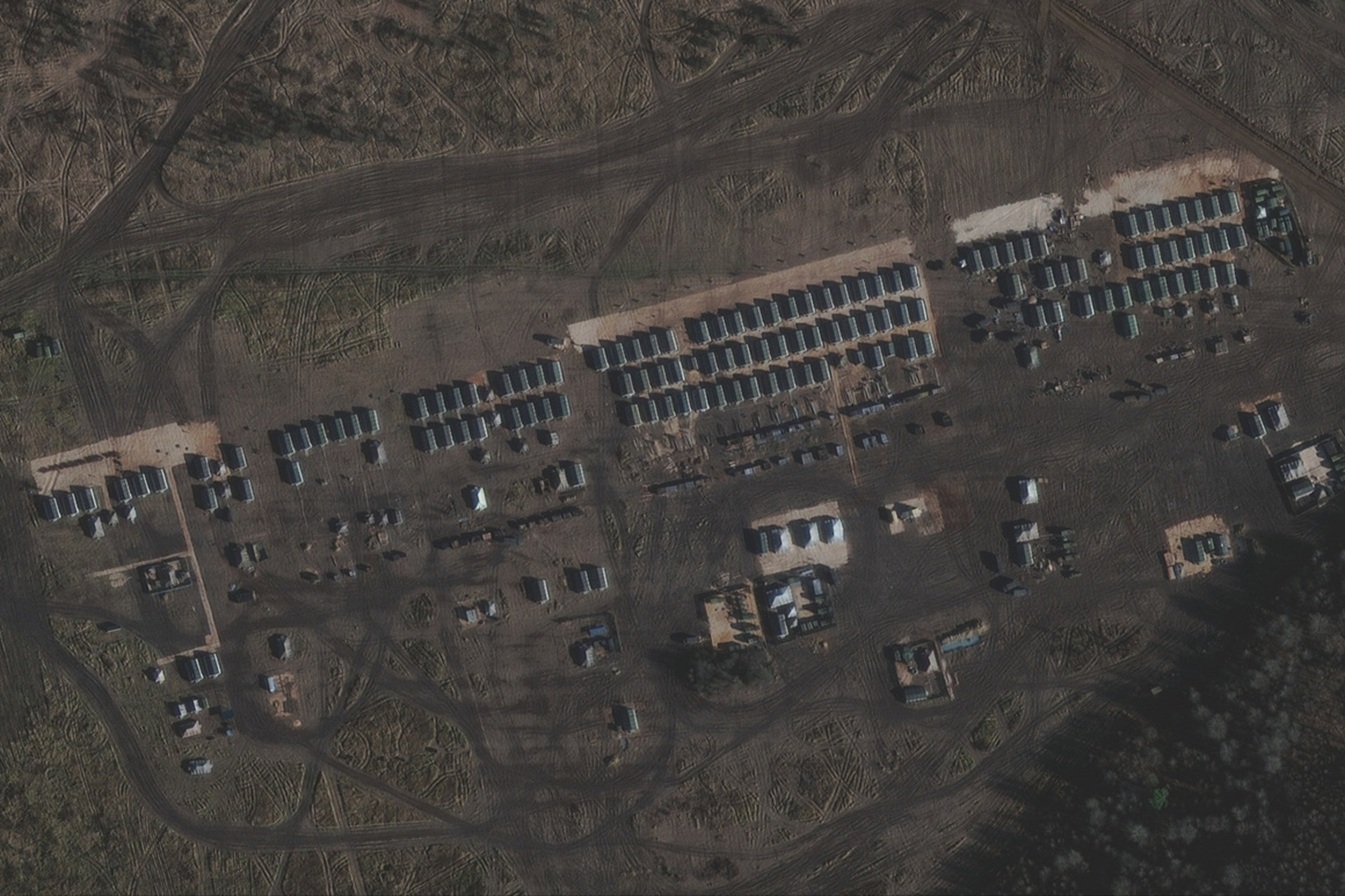 На спутниковых снимках видны воинские палатки и административная территория.